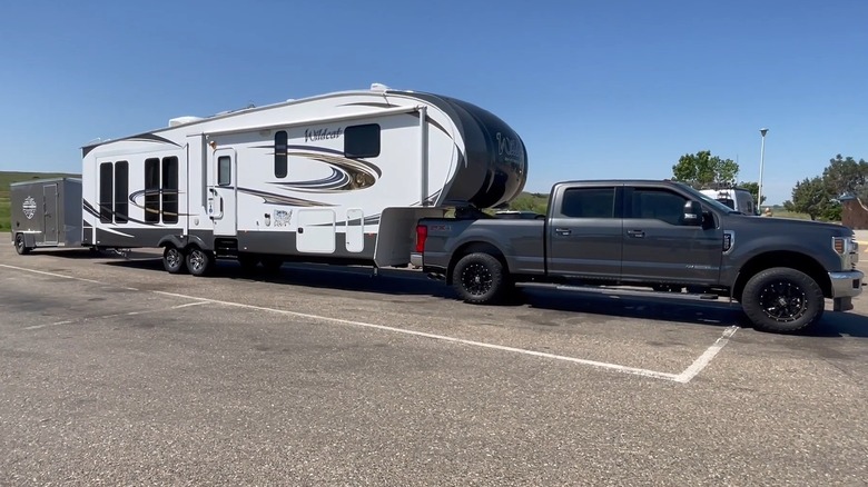 A truck pulling an RV that's pulling another trailer
