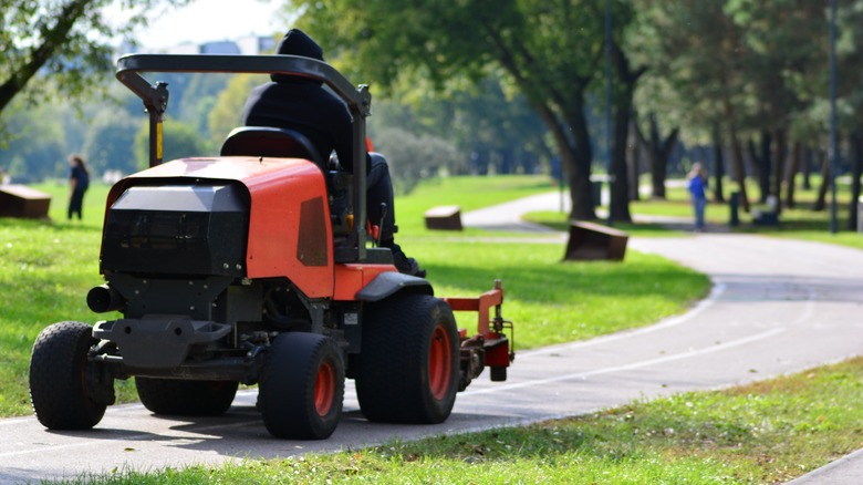 A professional driving a lawn mower on a track