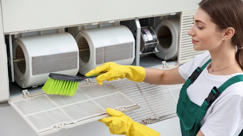 A person cleaning out an air conditioner filter.