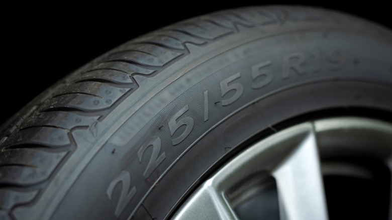 A closeup of a car tire's sidewall showing its size