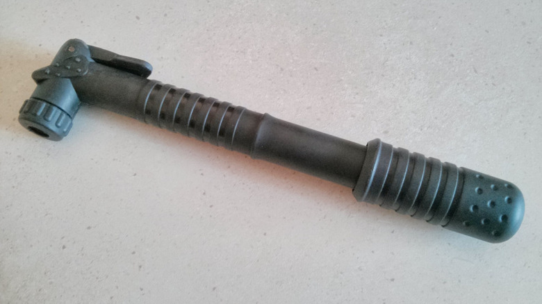 A black manual bike pump on a white surface