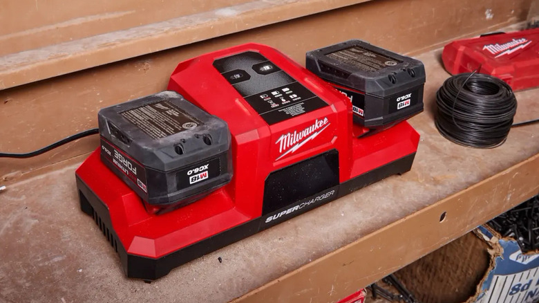 A Milwaukee M18 Super Charger plugged in and charging batteries.