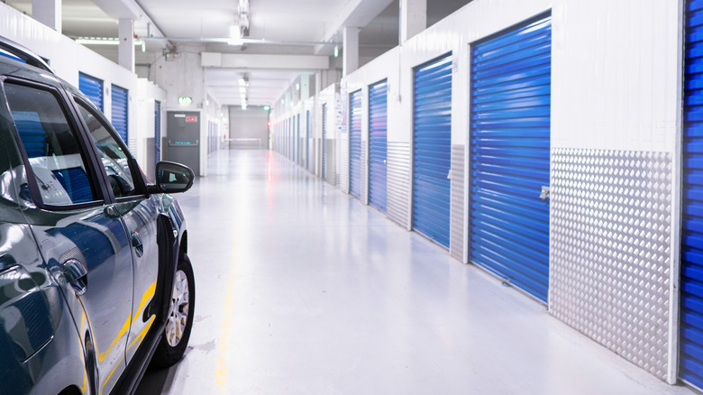 Car parked inside self storage facility with blue metal doors.