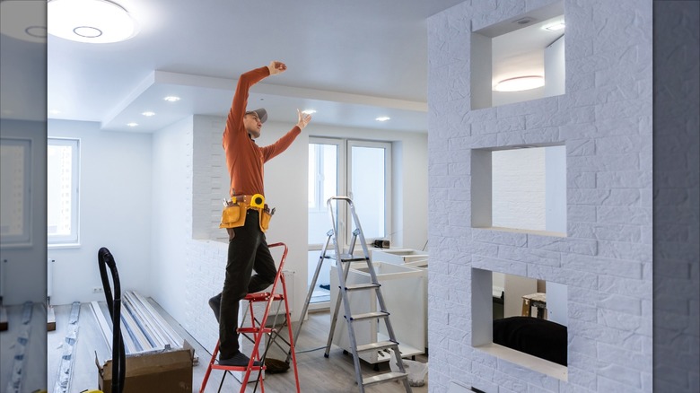 Installing a ceiling mount while standing on a ladder.