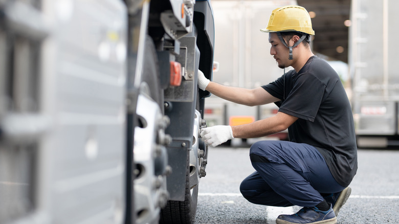 Man inspecting truck tires
