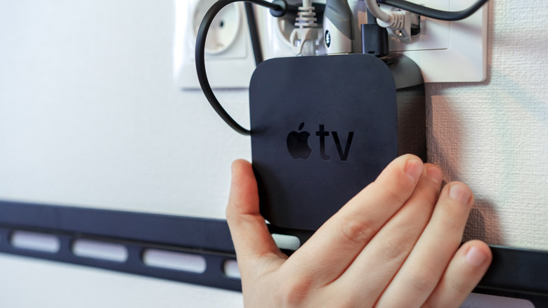 Hand installing Apple TV on the wall