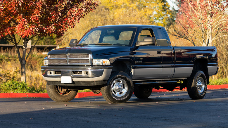 An older RAM 2500 with a two-tone black and silver exterior, front 3/4 view