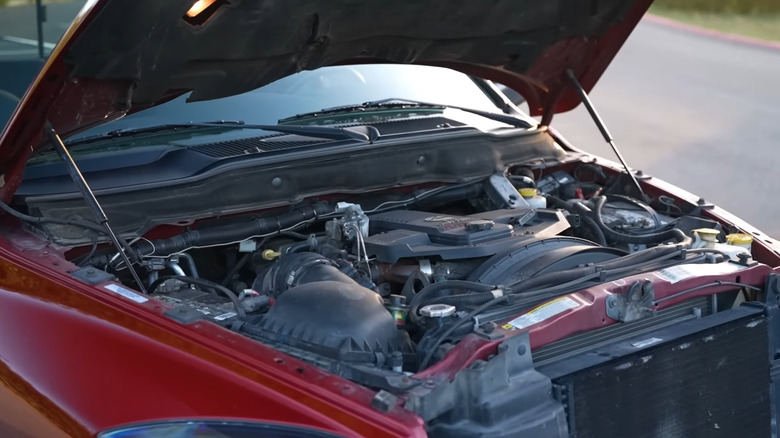 A 6.7-liter Cummins engine under an open hood of a red pickup truck