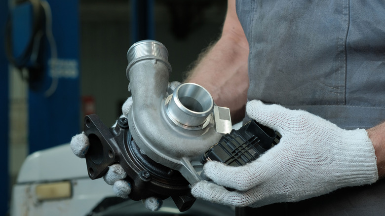 A new turbocharger is in the hands of an auto mechanic