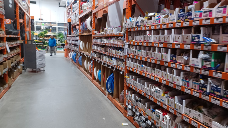 A person walking by Home Depot shelves.