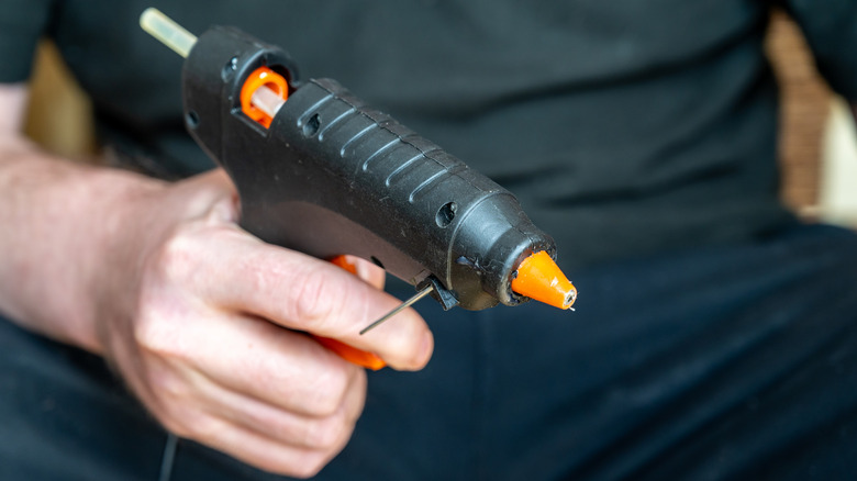 Person holding a hot glue gun