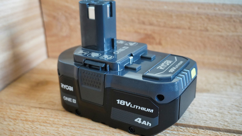 A Ryobi power tool battery on wooden surface