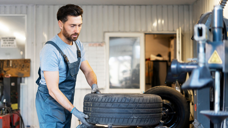 Mechanic servicing a wheel on a tire changer