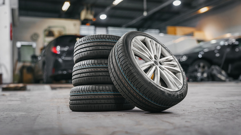 A stack of four tires in the middle of a car garage