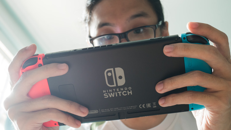 Person playing Nintendo Switch handheld