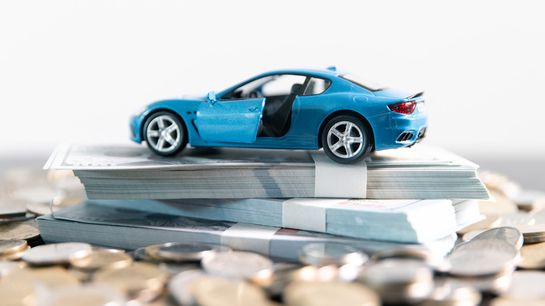 A blue model car on a stack of currency