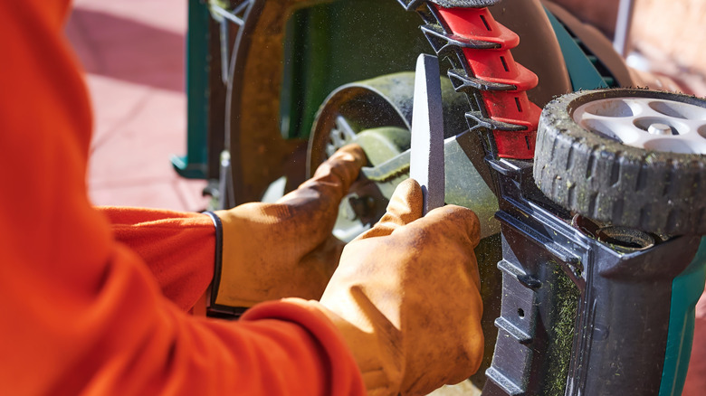 Man sharpening lawn mower blade