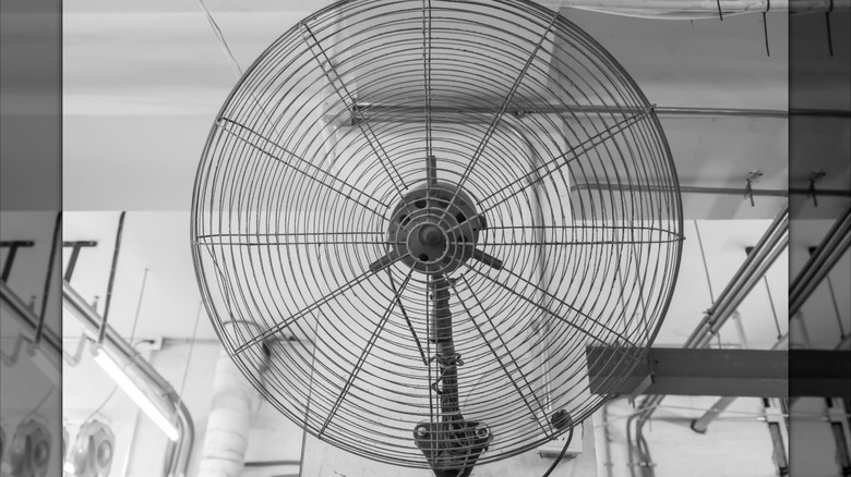 Um grande ventilador montado em uma parede de garagem