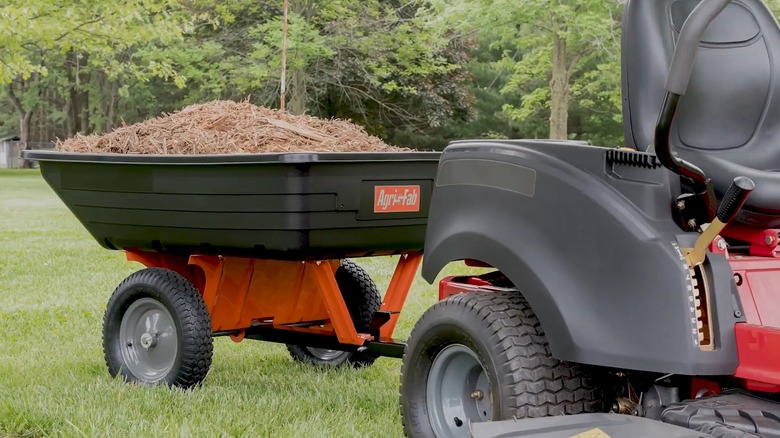 A Zero Turn Mower Pulling A Dump Cart With Mulch