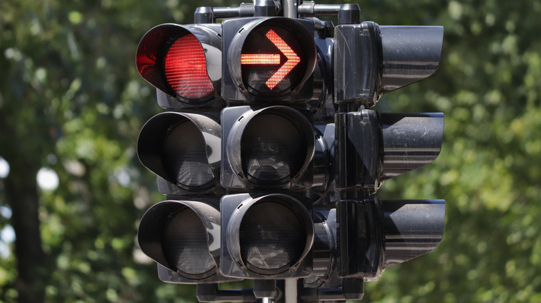 A traffic light on red with a red arrow.