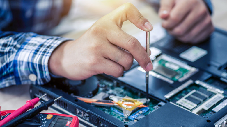 A person taking apart a laptop