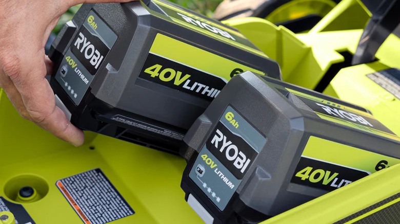 Hand plugs in a pair of Ryobi 40V 6Ah batteries.
