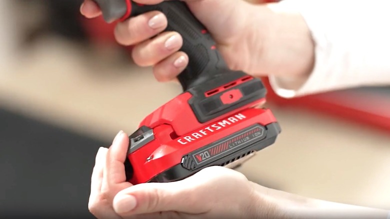 Person installing V20 battery on Craftsman device