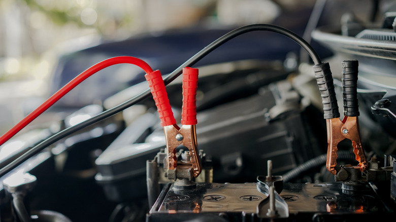 Close-up of car charger cable jump starting a dead car battery.