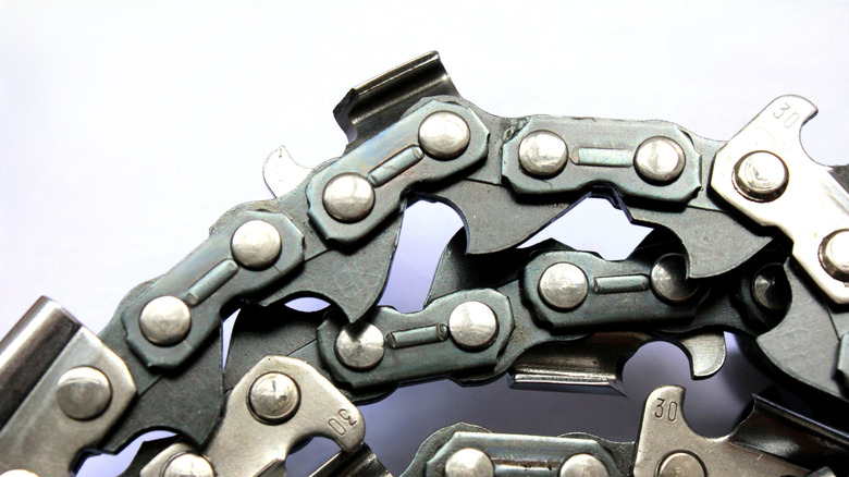 Close-up of a chainsaw chain against a white background.