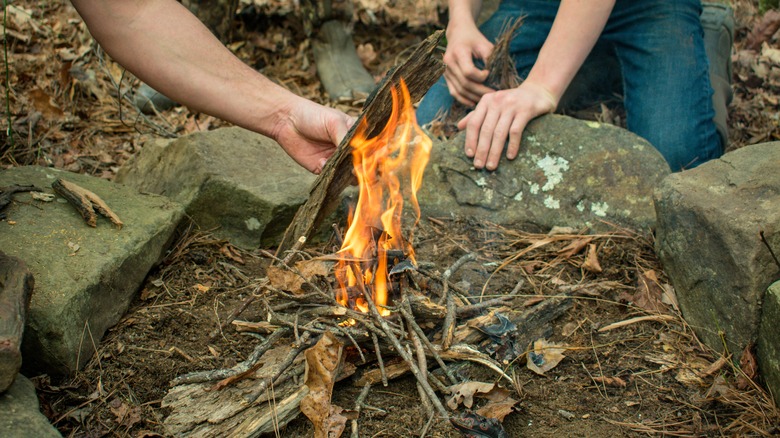 Two people starting a campfire