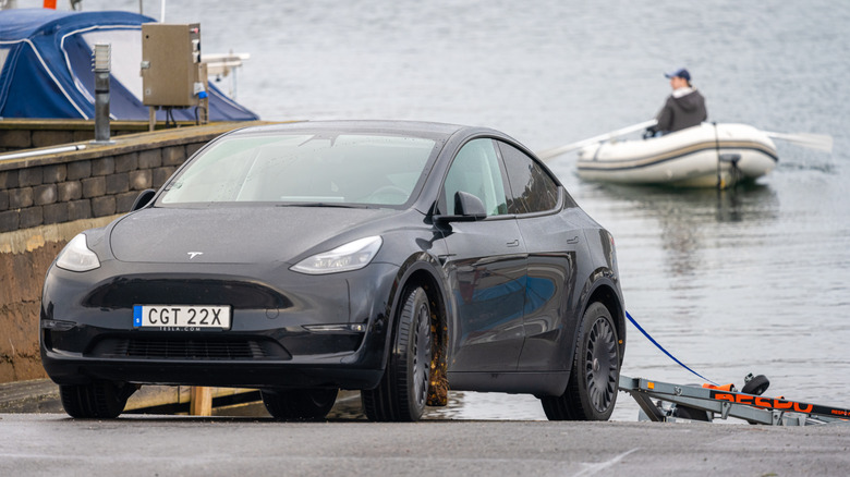 black tesla model 3 with a boat trailer