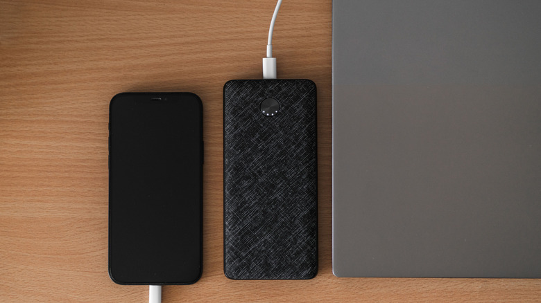 An iPhone and a power bank getting charged via a USB-C charger.