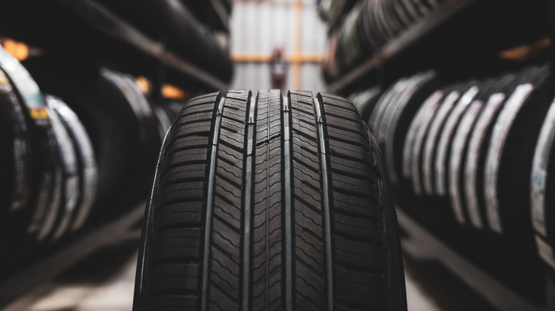 A new tire is placed on the tire storage rack in the car workshop