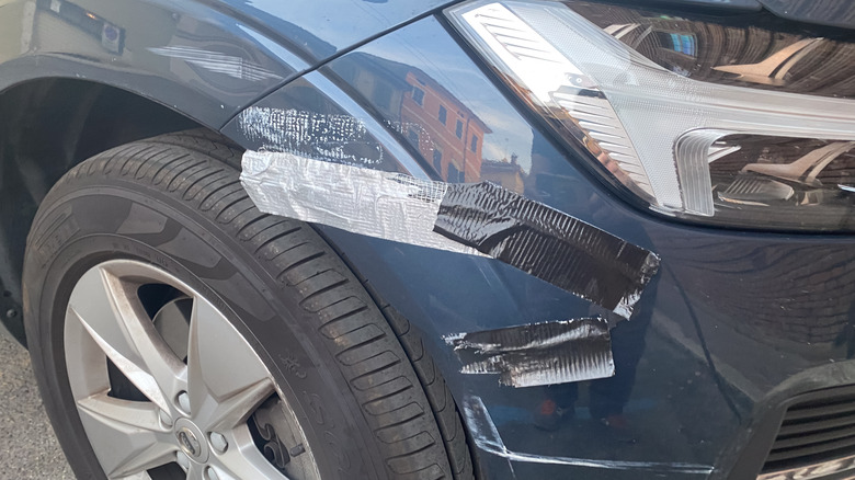 duct tape used to patch a broken front bumper on a blue car