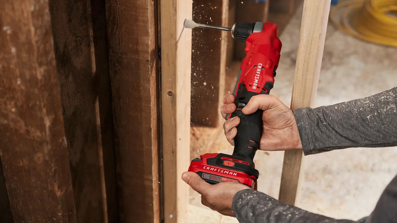 A person using a Craftsman right-angle drill.