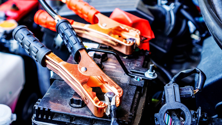 Jumper cable clamps attached to a dead battery