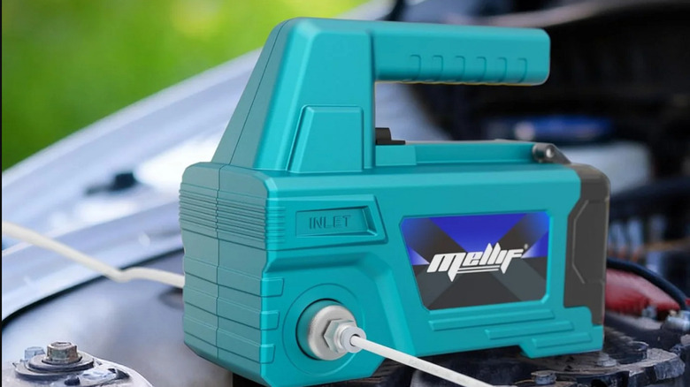 A blue Mellif oil pump sitting under an open car hood