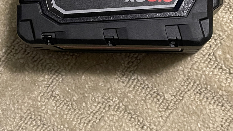 A Milwaukee M18 battery on its side.