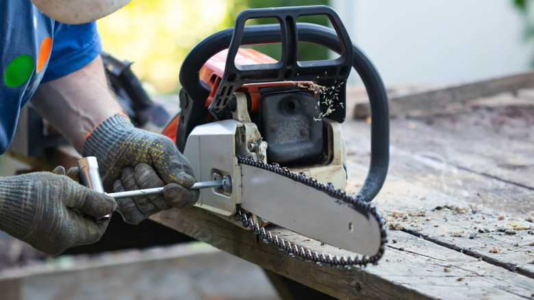 Man fixing broken chainsaw