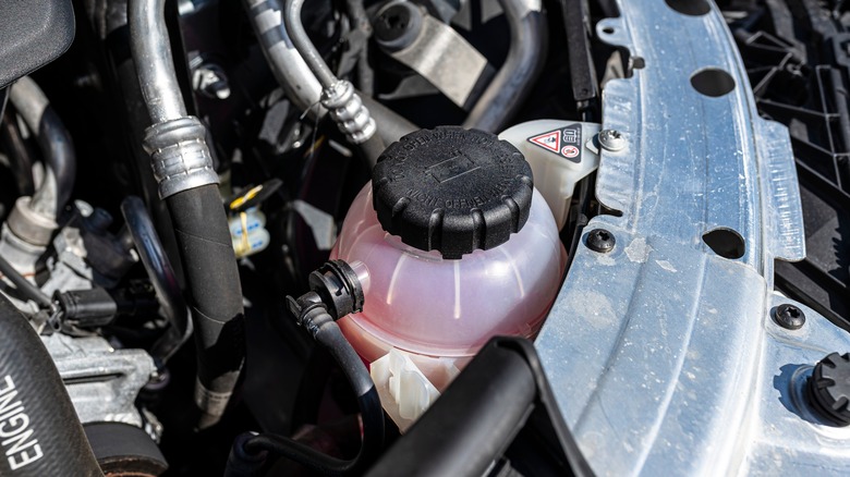 Closeup shot of car engine with pink diesel coolant in coolant reservoir