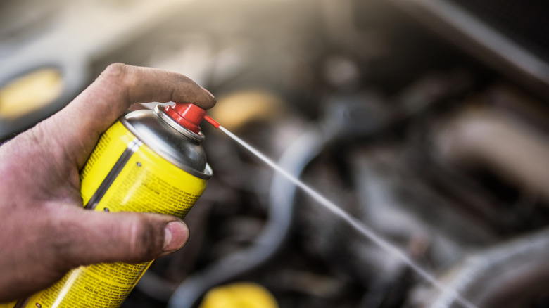Person spraying a can of WD-40