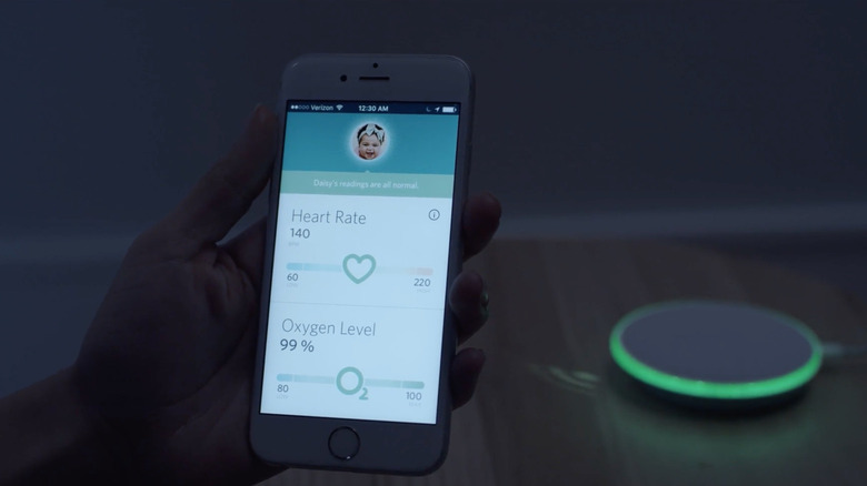 Person checking Owlet app for baby stats