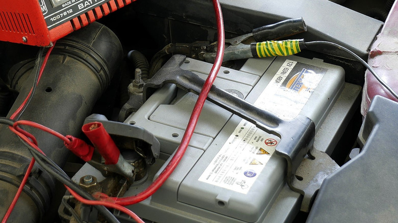 Car battery under the hood with cables hooked up to the terminals