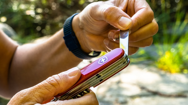 A person opening a Victorinox Swiss Army Knife