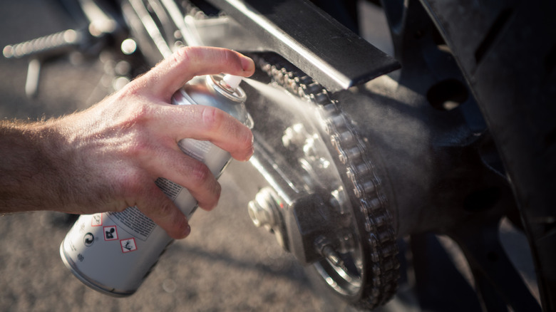 Person spraying motorcycle chains