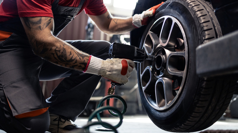 A pneumatic tool being used to remove lug nuts