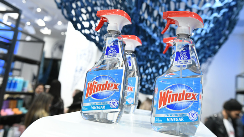 Four bottles of Windex being displayed on white table