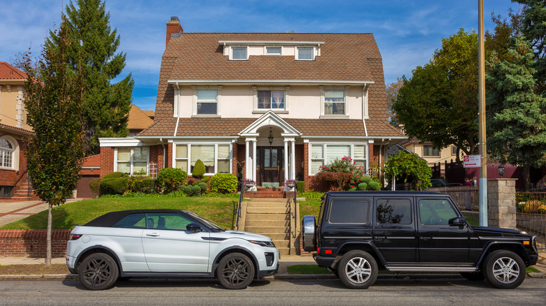 House in Bay Ridge with Mercedes-Benz G-class SUV and Land Rover Range Rover Evoque SUV parked in front of the house, Brooklyn, New York.
