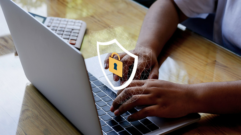 Man using a laptop with data protection icon in the center