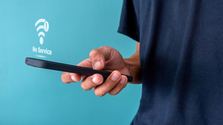 Man holding phone with no signal